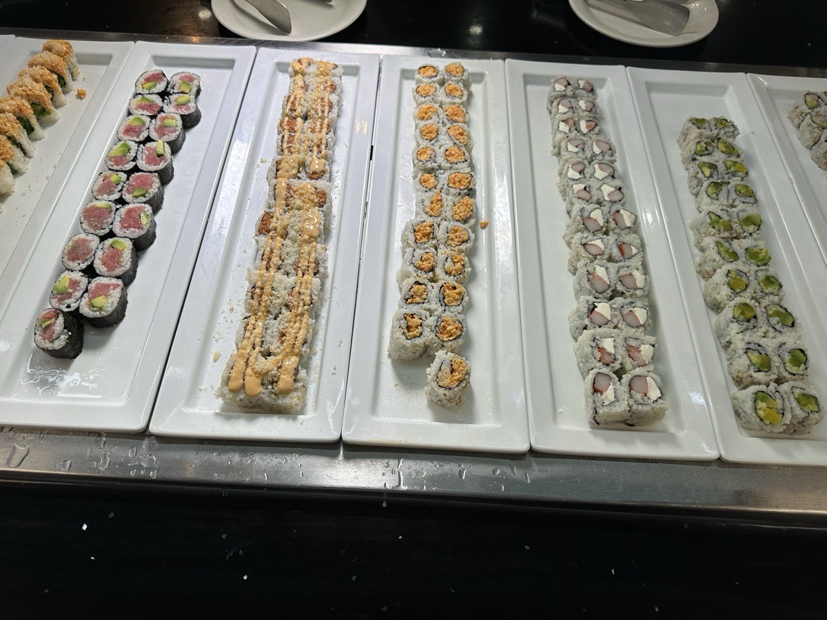 Maki and speciality rolls. Assorted maki and speciality sushi rolls on white platters
