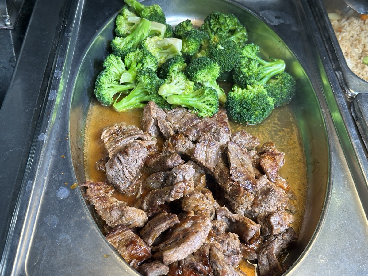 Beef in brown sauce served beside steamed broccoli
