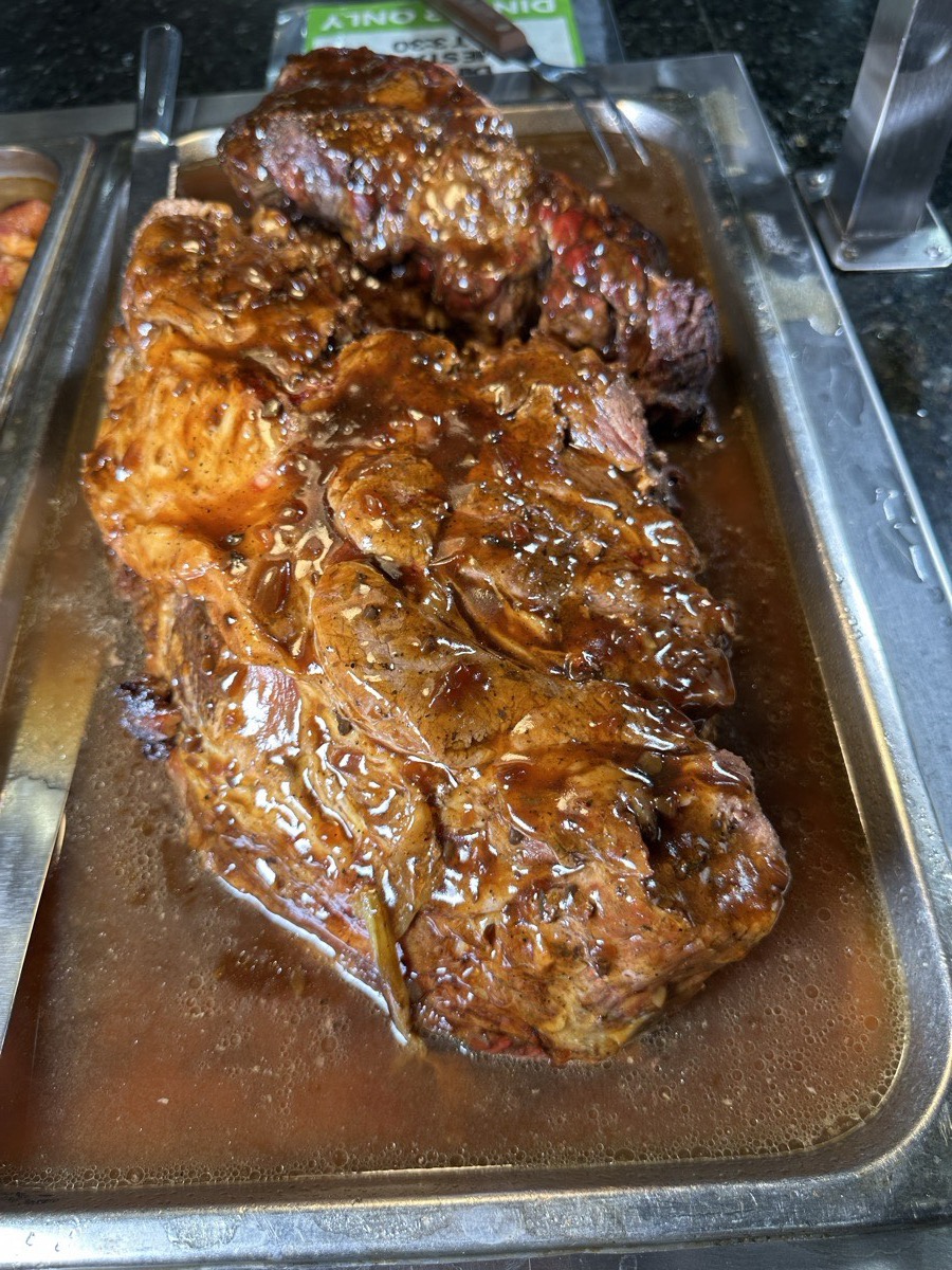 A braised and roasted pork joint in a serving tray