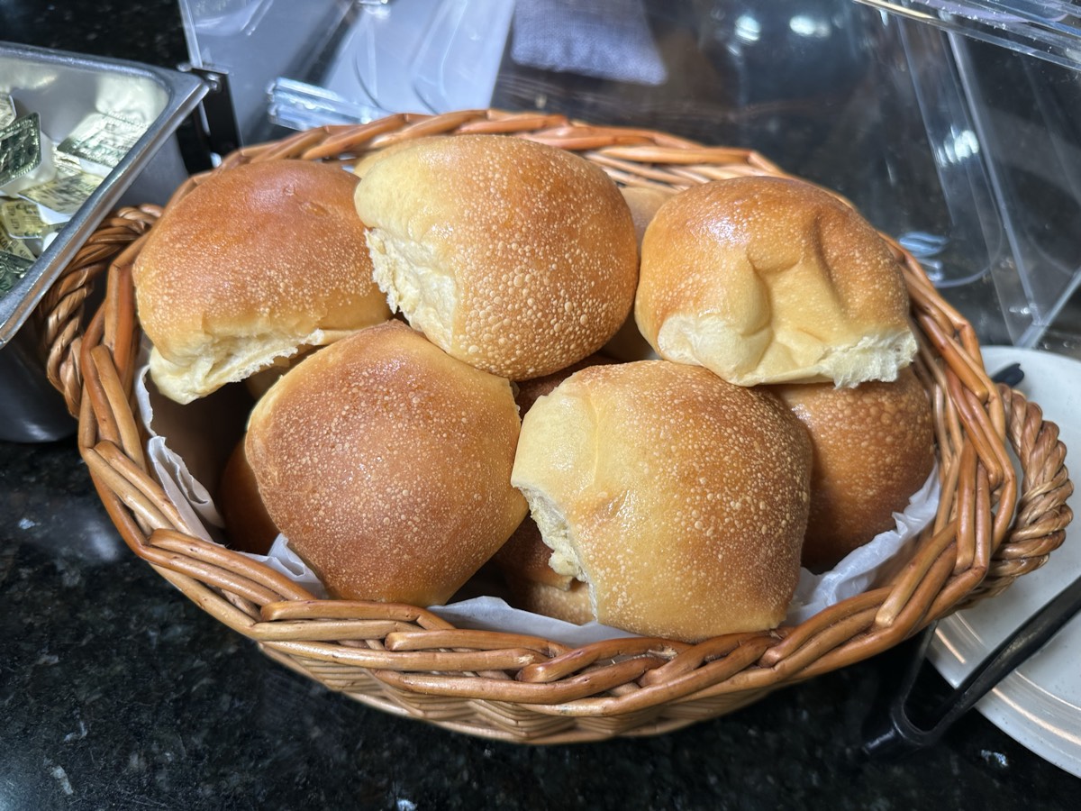 Fresh bread rolls A wicker basket of freshly baked dinner rolls on the counter