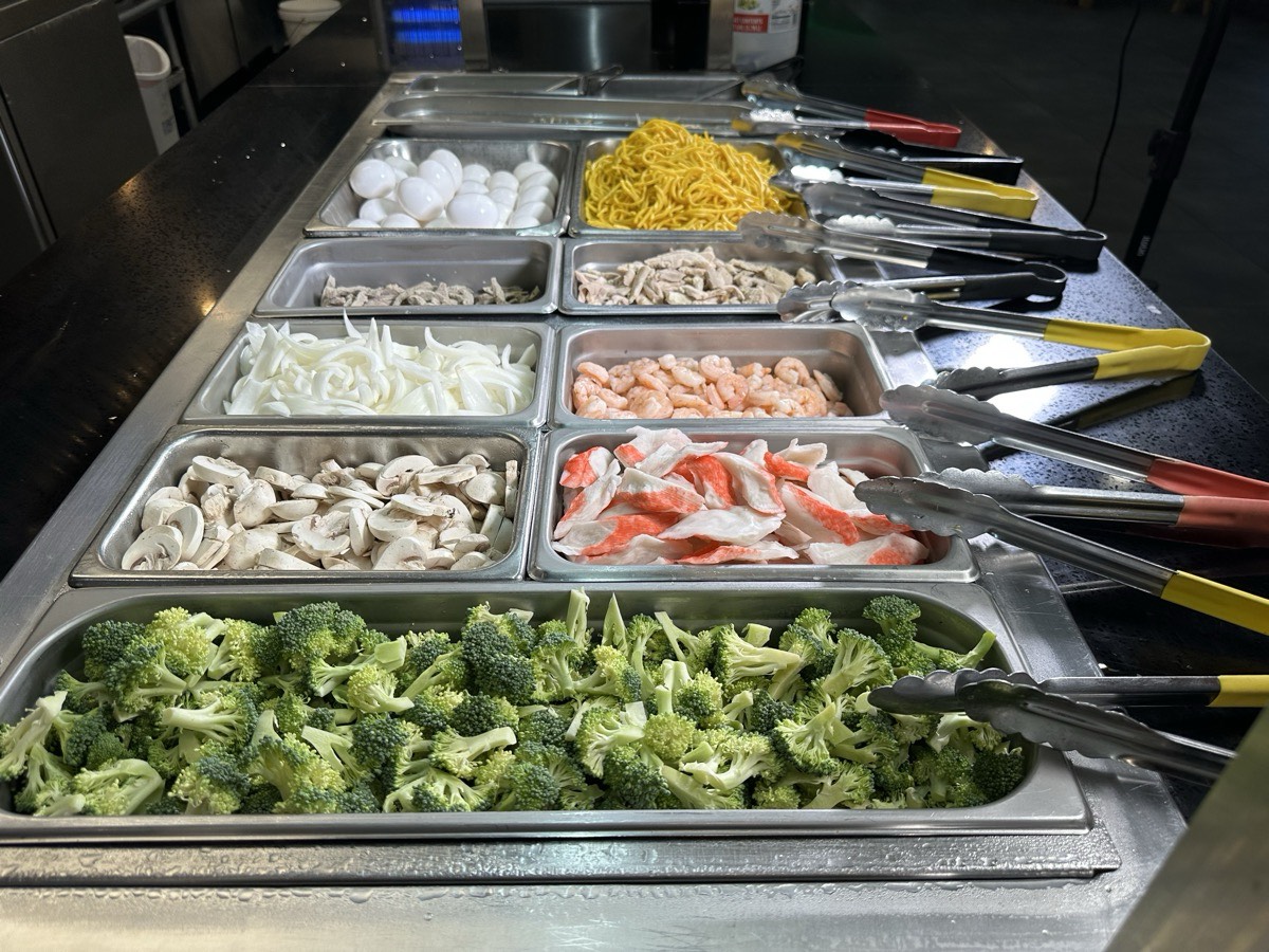 Vegetables on the line. Serving bins of broccoli, shrimp and sweetcorn