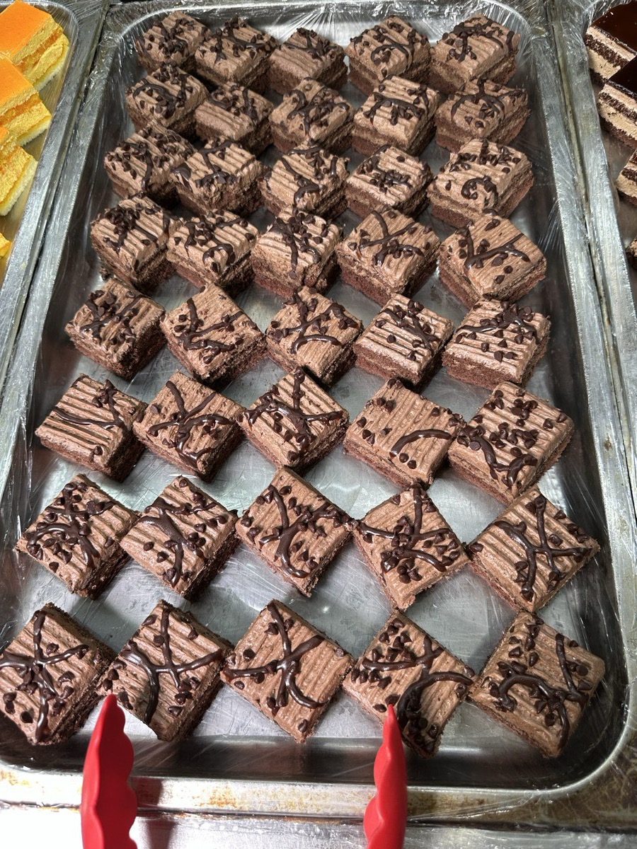 Chocolate cake. A tray of chocolate cake squares finished with chocolate drizzle