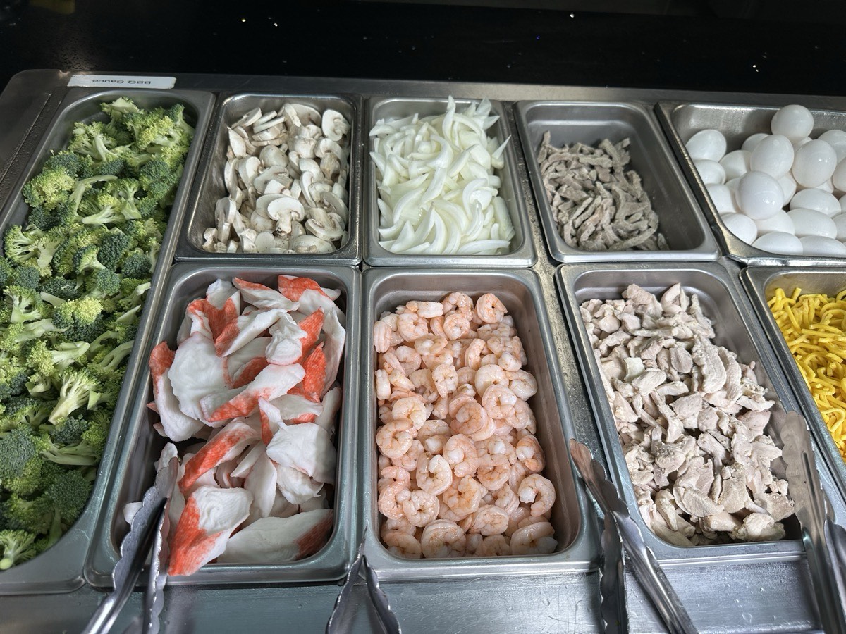 Prep bins of broccoli, mushrooms, onions, bean sprouts and shrimp