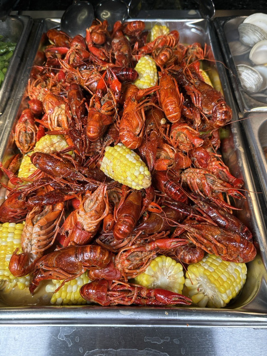 Crawfish boil with corn. A tray of seasoned crawfish boiled with corn on the cob