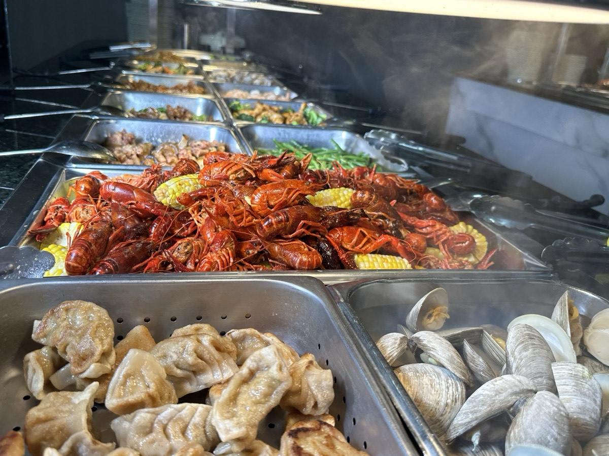 Trays of crawfish, dumplings and clams along the hot line