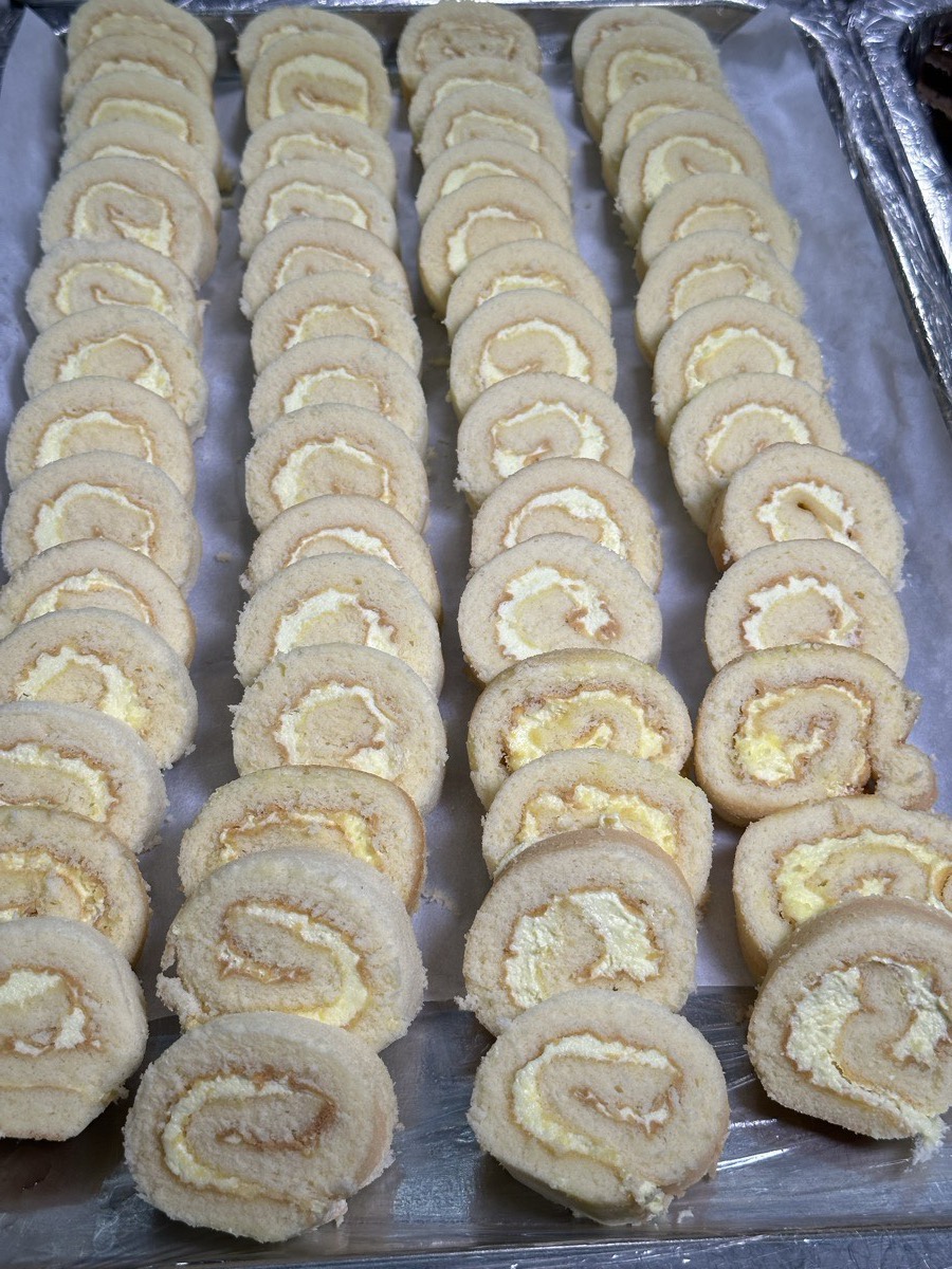 Rows of cream-filled pastry rolls on a tray