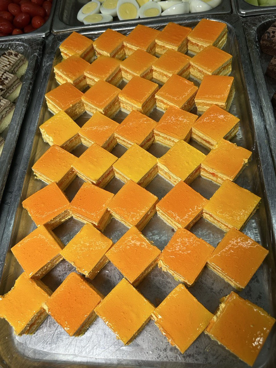 A full tray of layered mango cake squares