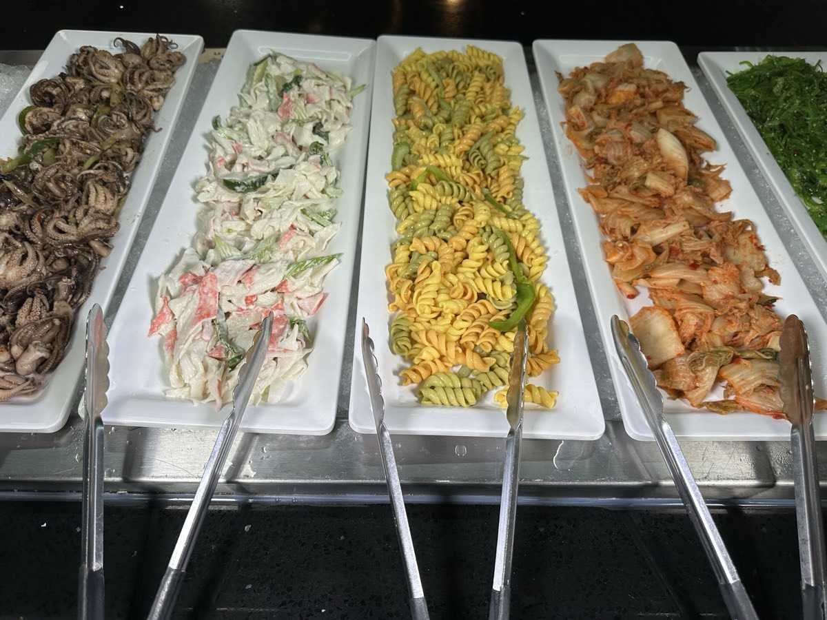 Octopus, crab salad and pasta salads. Baby octopus, crab salad, pasta salad and seasoned vegetables in trays