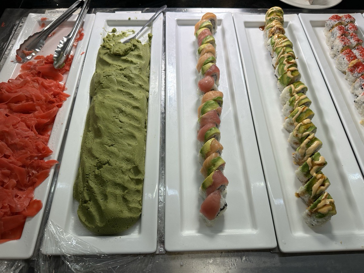 Platters of salmon sashimi, wasabi and assorted sushi rolls