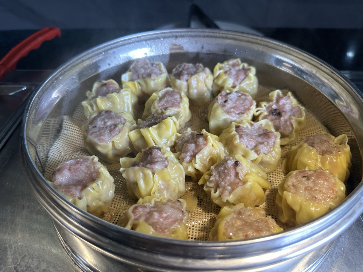 Dim sum and shumai Pork shumai steaming in a bamboo basket